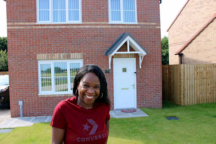 Woman smiling outside of her home