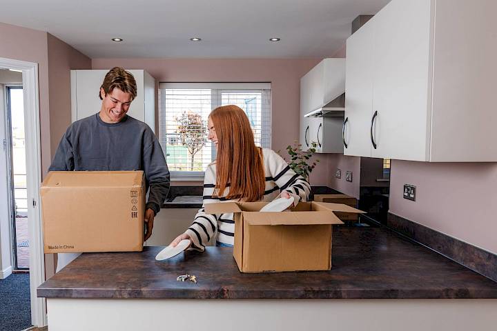 Young homeowners unpacking boxes in new home