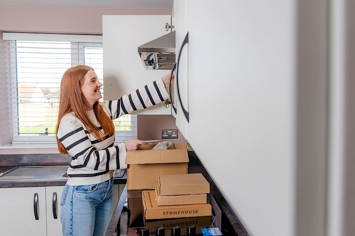 young woman unpacking boxes in her kitchen